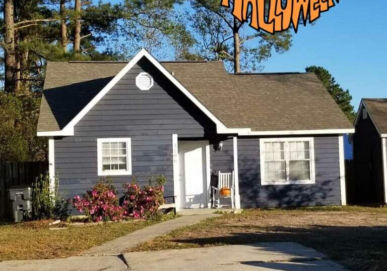 Cozy house decorated with a Halloween sign in the yard.
